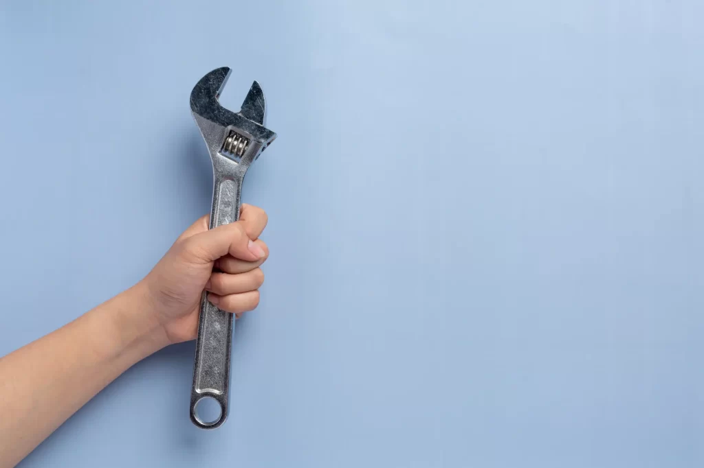 woman-holding-metal-wrench-labor-day-background-concept